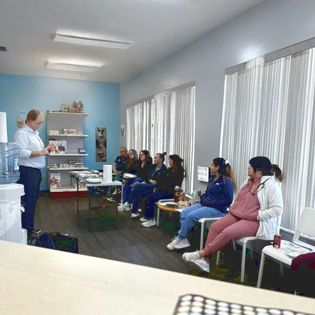Staff training in the light and airy waiting room, with full length windows on one side of the room. A selection of products available to purchase are showcased at one end of the room.